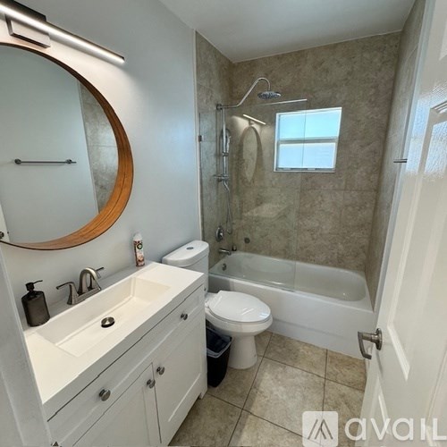 A bathroom with a white sink, toilet, and bathtub.