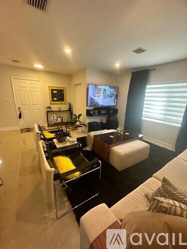 A living room with a black and white color scheme and a flat screen TV.