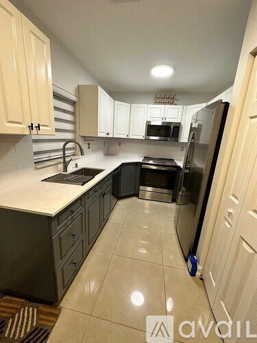 A kitchen with a refrigerator, microwave, and oven.