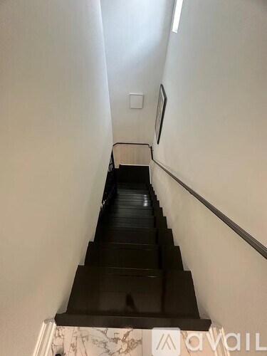 A staircase with a black railing and steps.