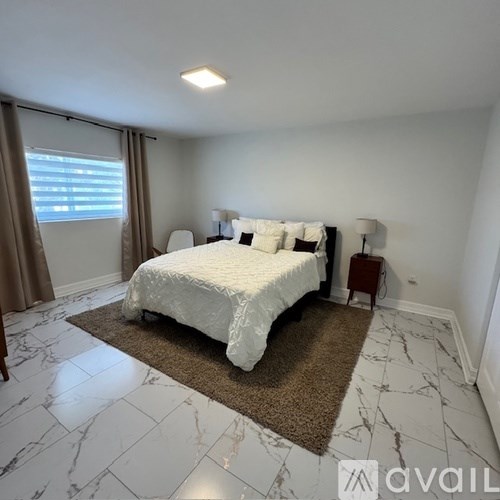 A bedroom with a large bed and a marble floor.