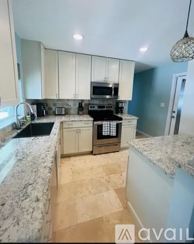 A kitchen with granite countertops and a stove top oven.