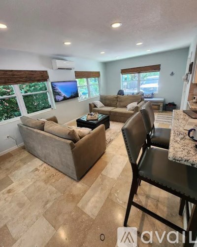 A living room with a couch, chair, and television.
