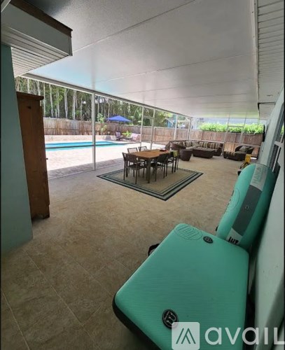 A living room with a pool outside the window.