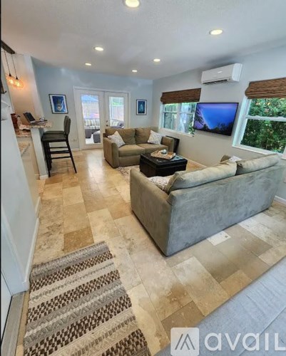 A spacious living room with a couch, chair, and television.