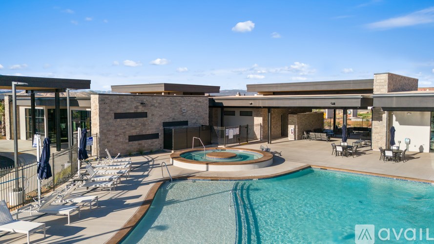 A large outdoor swimming pool with lounge chairs and a building in the background.