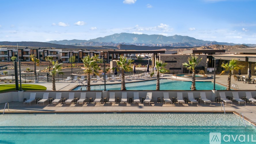 A pool area with lounge chairs and a mountain range in the background.