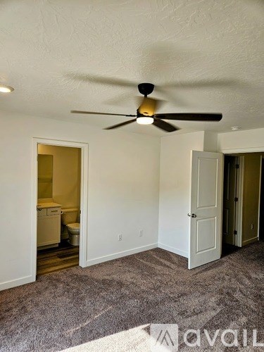 A room with a ceiling fan and a carpeted floor.