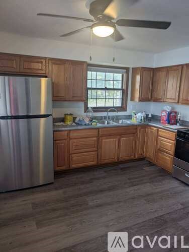A kitchen with wooden cabinets and a stainless steel refrigerator.