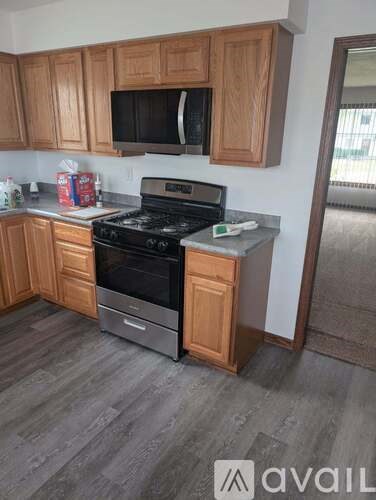A kitchen with wooden cabinets and a black stove top oven.