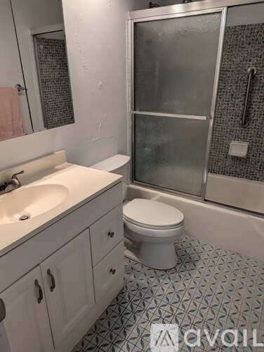 A white toilet sits in a bathroom with a tiled floor.