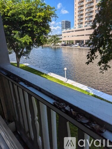A view from a balcony overlooking a river and a cityscape.