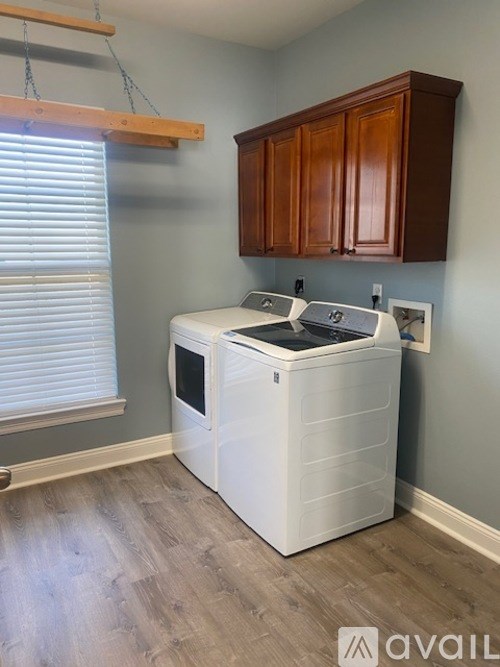 A white dishwasher is in a kitchen with wooden cabinets.