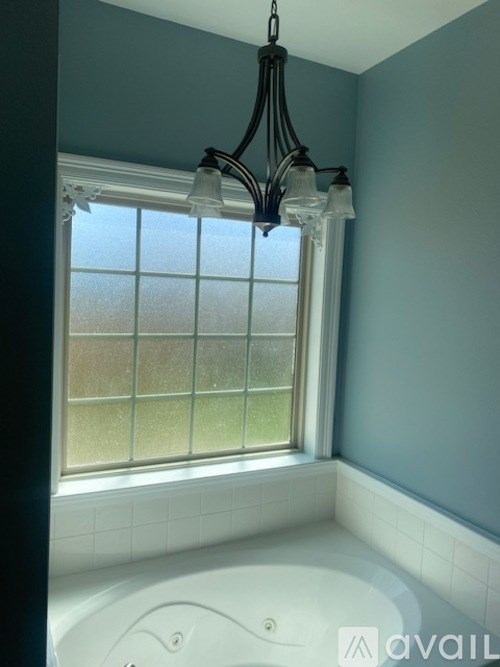 A bathroom with a tub and a window.