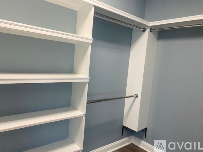 A white shelving unit with four shelves is mounted on a wall.