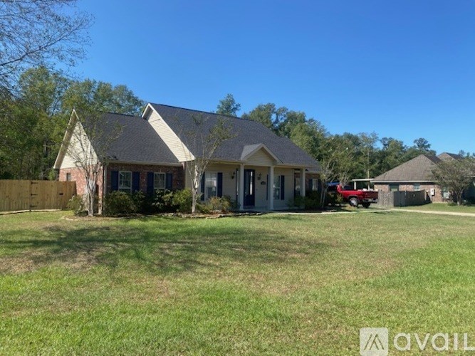 A house with a red car parked in front.