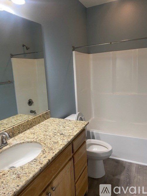 A bathroom with a granite countertop and a white toilet.