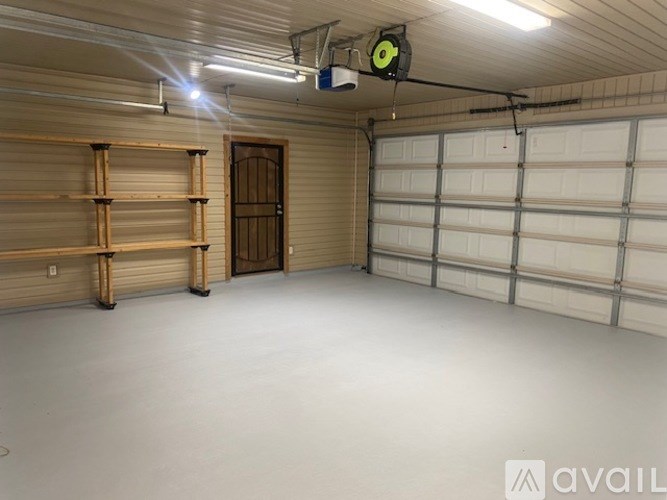 A garage with a white floor and a white ceiling with a light on it.