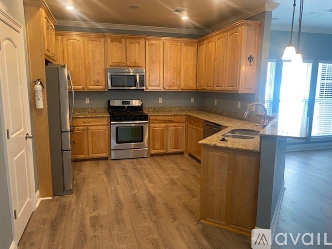 A kitchen with wooden cabinets and a granite countertop.