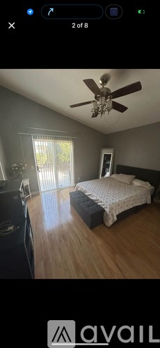 A bedroom with a bed, dresser, and ceiling fan.