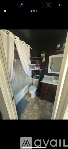 A bathroom with a toilet, sink, and shower curtain.