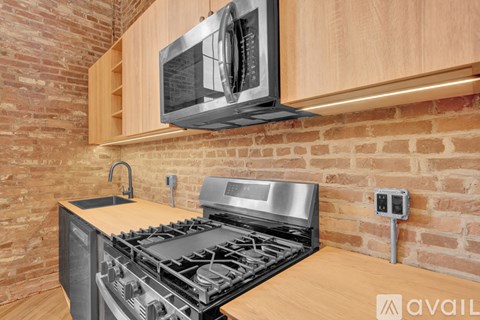 A modern kitchen with a stove and a microwave mounted above it.
