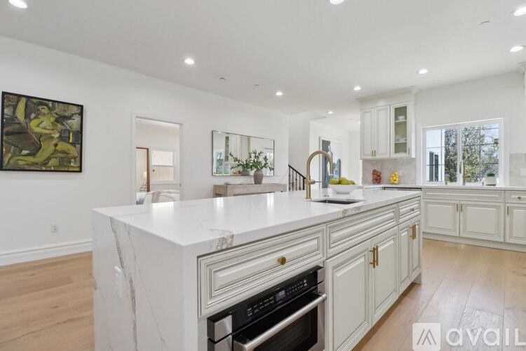 A modern kitchen with a large island and wooden floors.