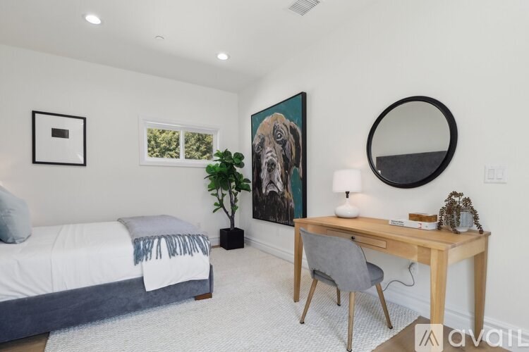 A bedroom with a bed, desk, and chair.