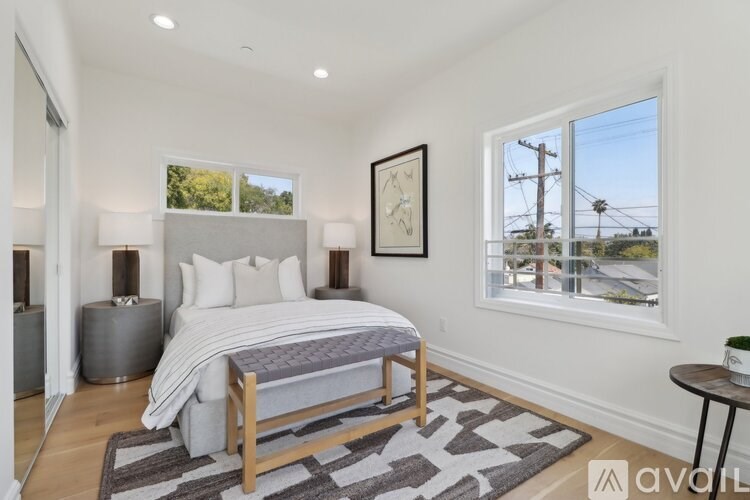 A bedroom with a bed, nightstand, and window.