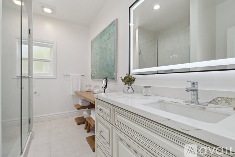 A bathroom with a white sink and a mirror above it.
