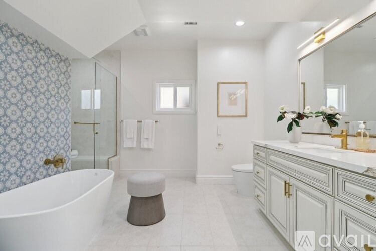 A bathroom with a white tub, sink, and toilet.