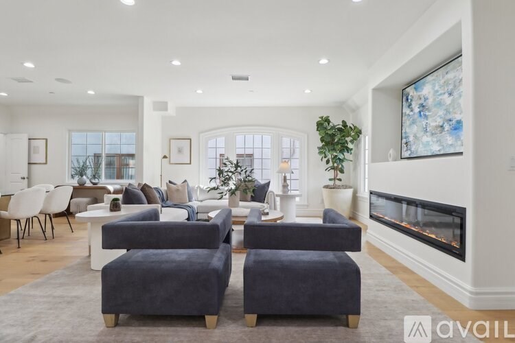 A living room with a fireplace and a painting on the wall.