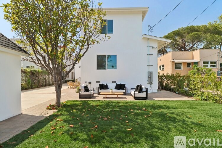 A white house with a tree in front of it.