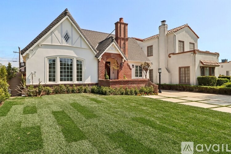 A large house with a well-manicured lawn in front.