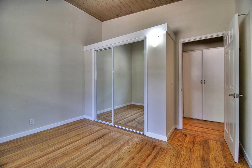 A room with a sliding door and wooden floors.