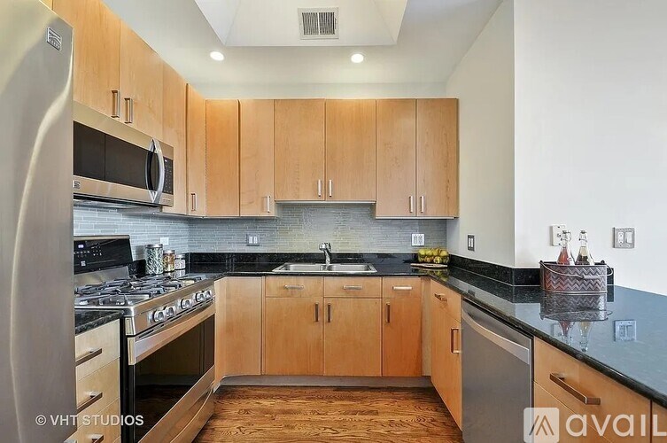 A kitchen with wooden cabinets and black countertops.