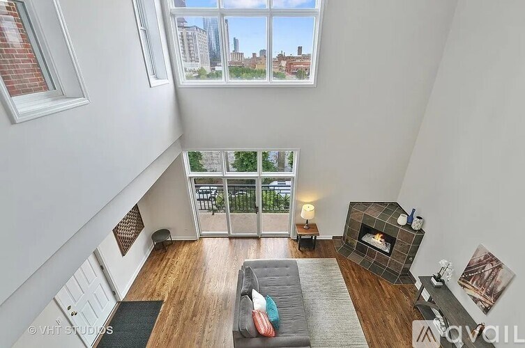A living room with a grey couch and a fireplace.