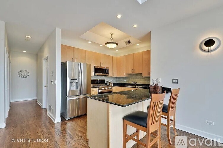 A kitchen with wooden cabinets and a black countertop.