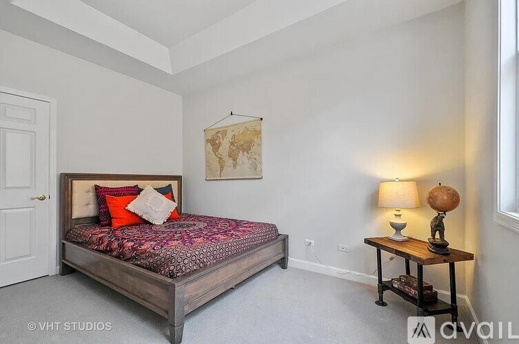 A bedroom with a bed, a lamp, and a small table.