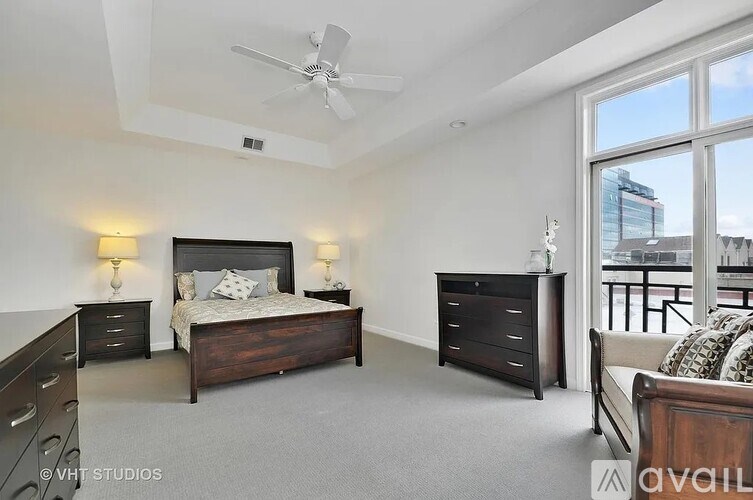 A bedroom with a large bed and a ceiling fan.