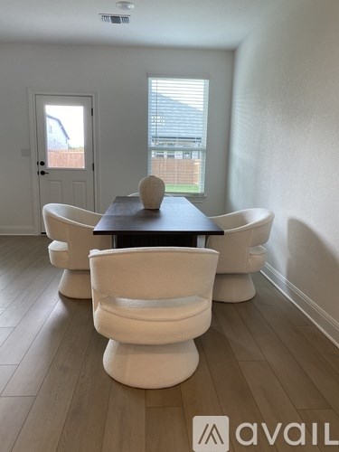 A dining room with a table and chairs.