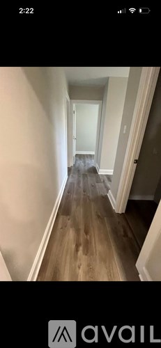 A long hallway with wooden floors and white walls.