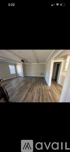 A room with wooden flooring and white walls.