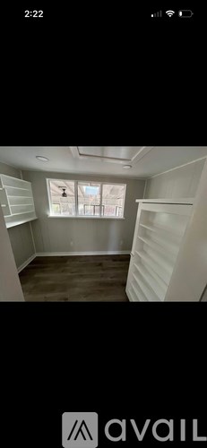 A room with a window and wooden flooring.