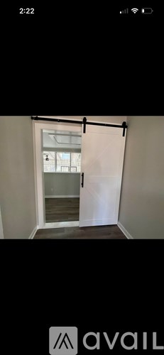 A white door with a black handle is open.