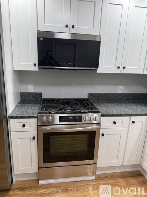 A kitchen with white cabinets and a black stove top.