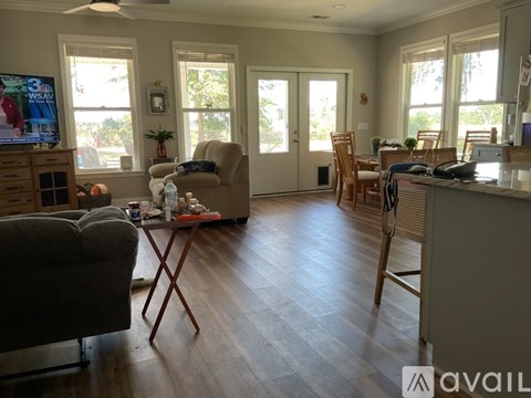 A living room with a grey couch and a wooden floor.