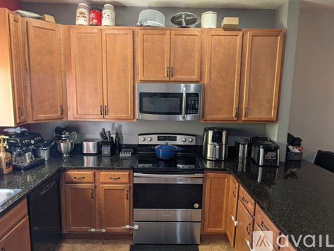 A kitchen with wooden cabinets and black appliances.