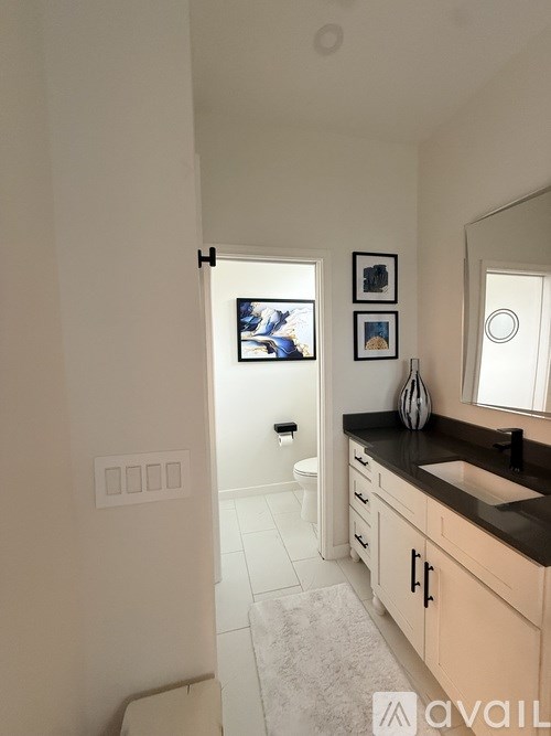 A bathroom with a sink, toilet, and a mirror.