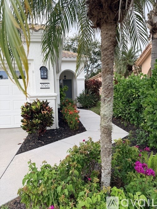 A white house with a black and white checkered walkway in front.